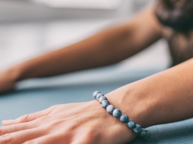 Nahaufnahme eines gestreckten Arms mit Armband während einer Yogaübung