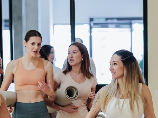 Kleine Gruppe von Frauen unterhält sich vor einer Yogastunde
